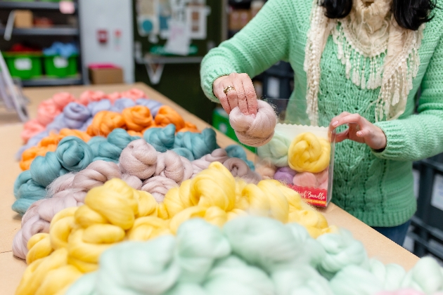 Lady packing wool bundles into packaging