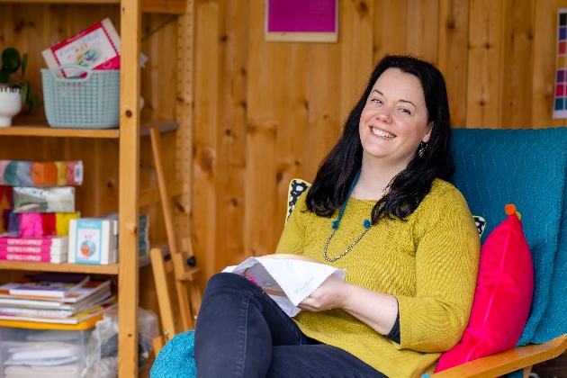 brunette lady sitting in armchair crafting