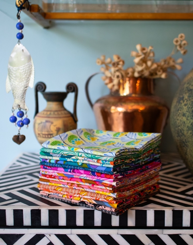 small pile of folded bright fabrics on a table