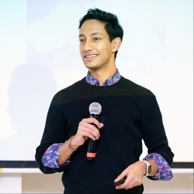 man in black sweatshirt holding microphone