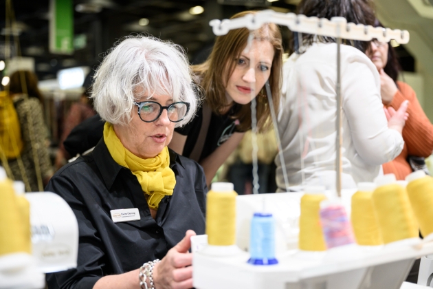 woman wearing yellow scarf working on her sewing machine